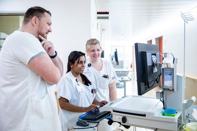 Drei Mitarbeitende der Station besprechen sich