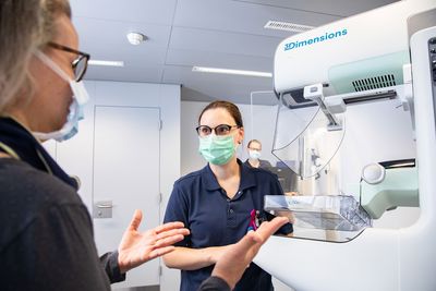 Eine Patientin und eine MRT-Fachfrau besprechen die anstehende Mammografie