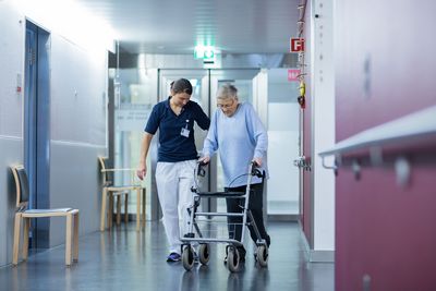 Eine Therapeutin begleitet eine ältere Patientin