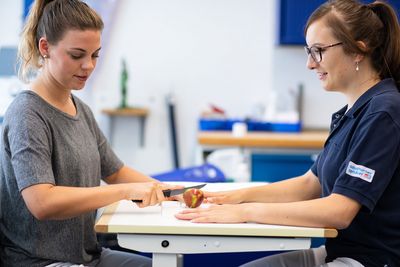 Die Patientin schneidet einen Apfel