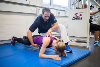 Der Physiotherapeut hilft einer Frau bei ihrem Training