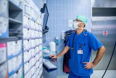 Ein Mann betrachtet das Regal mit Medikamenten