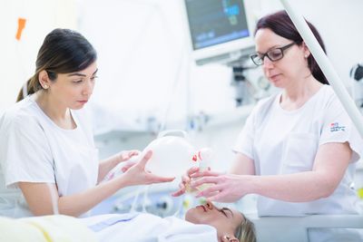 Zwei Pflegerinnen behandeln eine Frau