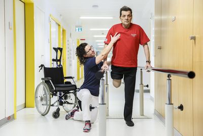 Eine Physiotherapeutin trainiert einen Mann mit einem amputierten Bein