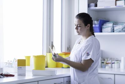 Eine Mitarbeiterin kontrolliert Medikamente