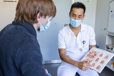 Die Hals-Nasen-Ohren-Ärztin spricht mit einem jungen Patienten